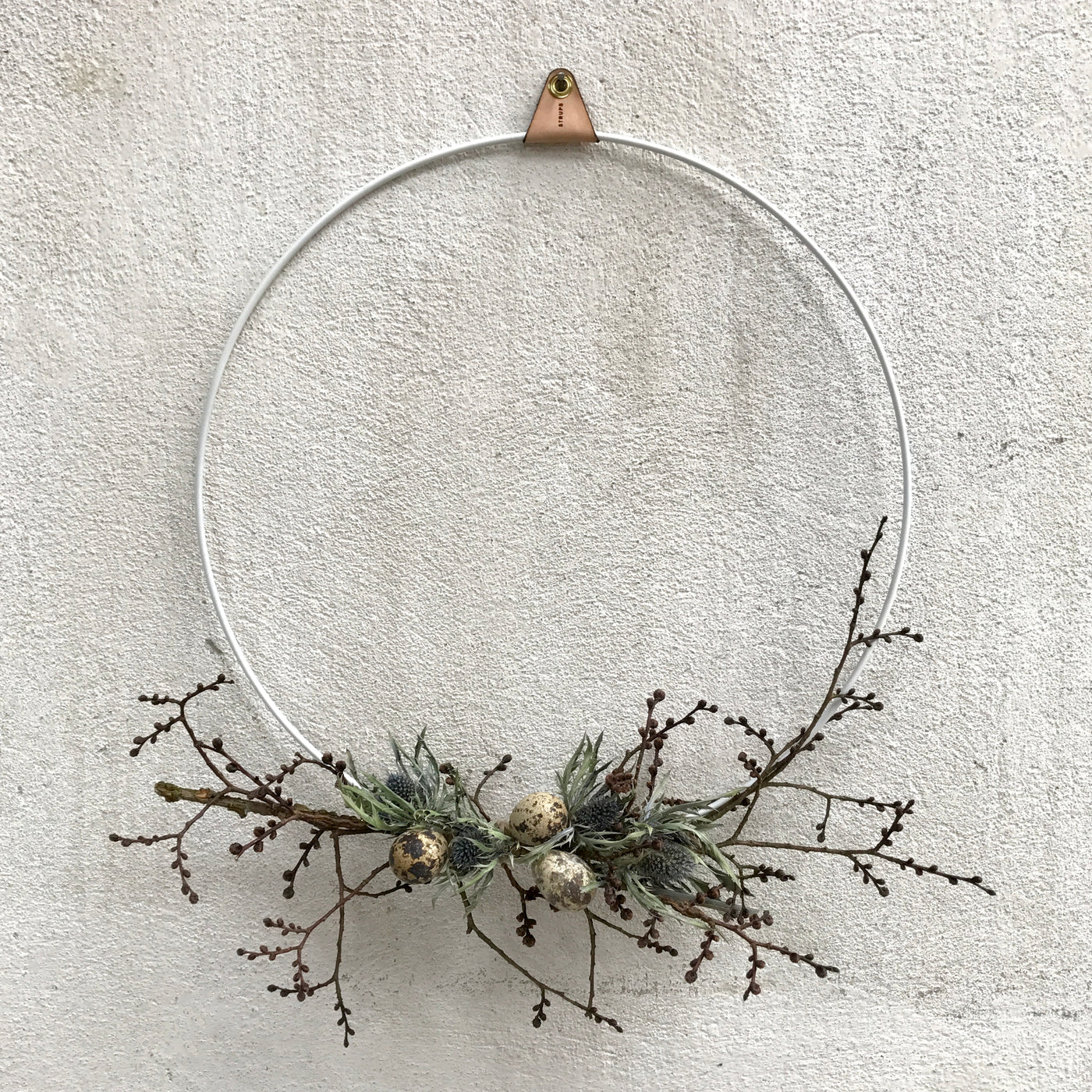 White Strups ring wreath decorated for Easter with branches dried flowers and eggs